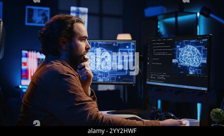 Computer scientist updating artificial intelligence neural networks, drinking coffee and writing code scripts in personal office. IT expert enjoying hot beverage while running AI simulations, camera B Stock Photo