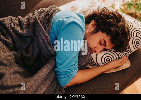 Young man sleeping peacefully on a comfortable couch at home Stock Photo