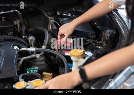 Woman checking engine on his car. Close-up woman's hand check engine oil A woman pulls out the dipstick to check the oil level of her car. Woman repai Stock Photo