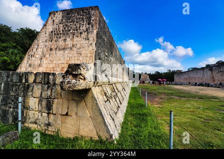 Kukulcan Serpent head sculpture close up with view of the West wall at the Great Ball Court,Juego de Pelota,Chichen Itza,Mexico Stock Photo