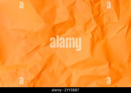 Top view and full frame of wrinkled or crumpled orange paper is used as crumpled orange paper background texture. Stock Photo