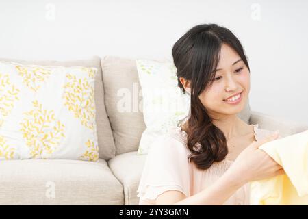 Young woman folding laundry Stock Photo