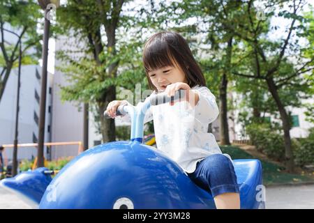 Child playing alone in park Stock Photo