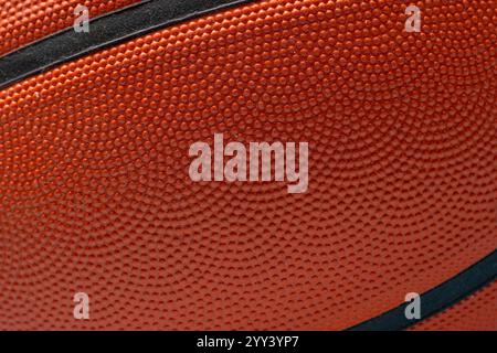 Orange basketball ball lit from above on blue background Stock Photo