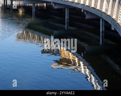 Abstract reflections of the boardwalk in the lake, Rushden Lakes nature reserve, Northamptonshire, UK Stock Photo