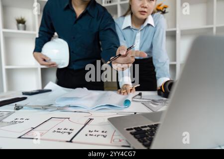 Engineers Collaborating on Architectural Design Plans in Modern Office Environment Stock Photo