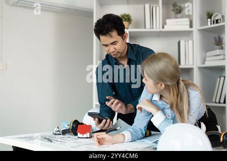 Engineers Collaborating on Architectural Design Project in Modern Office Setting Stock Photo