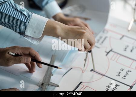 Architects Collaborating on Blueprint Design with Precision Tools in Modern Office Setting Stock Photo