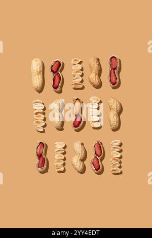 Arranged raw peanuts in different stages of peeling, revealing their texture and orange hues. The image on an orange background depicts whole peanuts Stock Photo