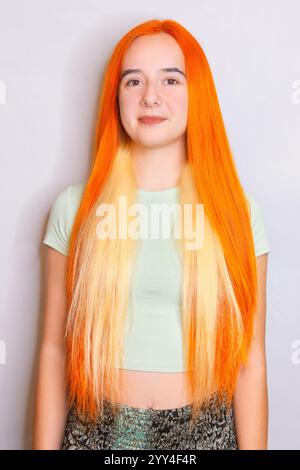 A striking hair transformation showcasing vibrant orange and blonde hues on long hair Perfect for a trendy, daring look that captures attention in any Stock Photo