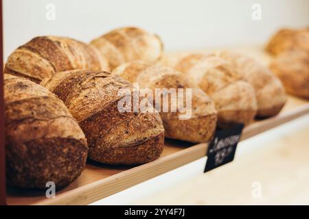 A cozy bakery shelf showcases freshly baked, crusty artisan bread loaves Capturing the warmth and aroma of a traditional bakery, perfect for food and Stock Photo