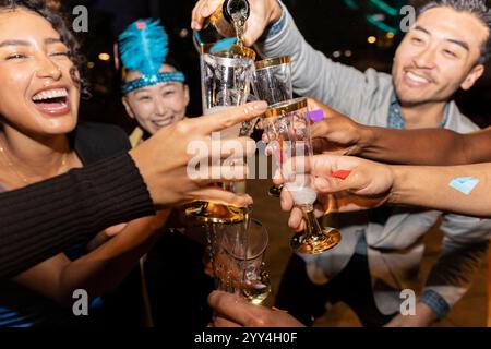 A lively city party where friends enjoy clinking glasses and celebrating together The atmosphere is filled with joy and laughter, creating unforgettab Stock Photo