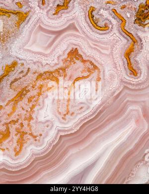 A close-up image of a pink and orange agate stone showcasing intricate natural patterns and textures. The swirling layers create a captivating abstrac Stock Photo