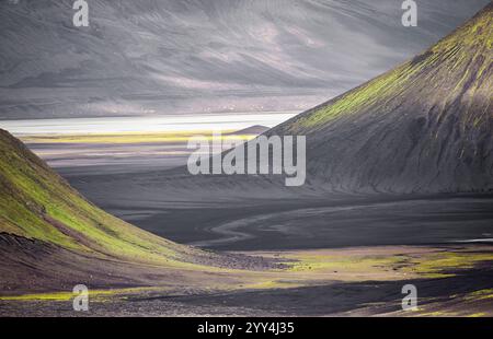 Breathtaking view of Icelandic highlands featuring smooth green slopes contrasting rugged, volcanic terrain A serene and captivating natural landscape Stock Photo