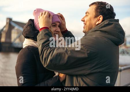 A young married man and woman share a joyful moment walking together in Wroclaw, Poland during the cool season. They are looking at each other, smilin Stock Photo