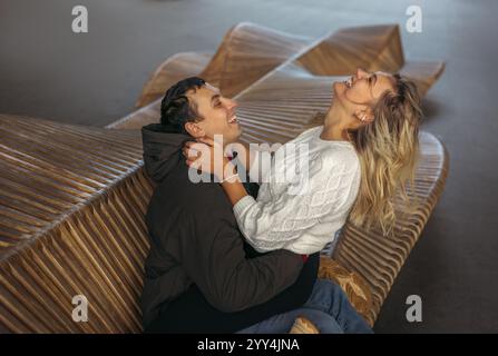 A young cheerful married couple, enjoy each other's company while in Wroclaw, Poland during the cold season. The woman is smiling at the man who is lo Stock Photo