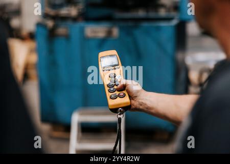Hand of male worker holding remote control at factory Stock Photo