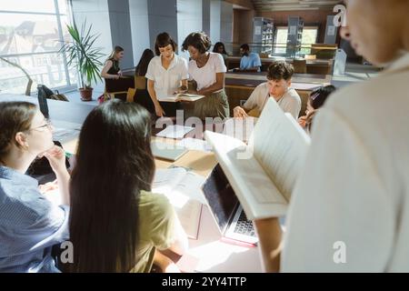 Multiracial group of university students studying in library at university Stock Photo