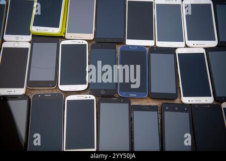 Bunch of old used mobile phones on street market. Equipment repair and maintenance services. Parts for assembly. Stock Photo