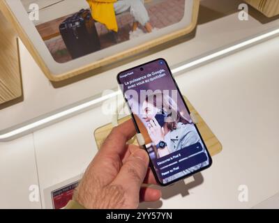 Strasbourg, France - Dec 17, 2024: A shopper examines the Google Pixel 8 smartphone in a store, showcasing its AI-powered features displayed on the screen Stock Photo