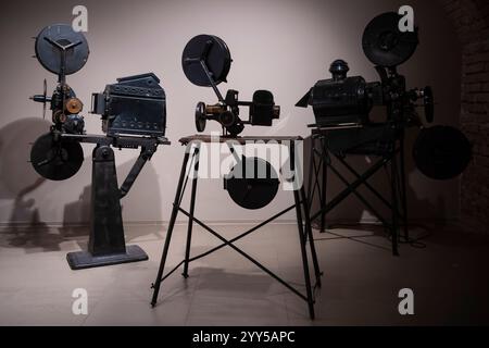 Vintage photo of cinema library with old video movie projectors and film reels on shelves. Stock Photo