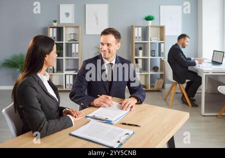 Two business people collaborating on work in office space, discussing project and focusing on tasks. Stock Photo