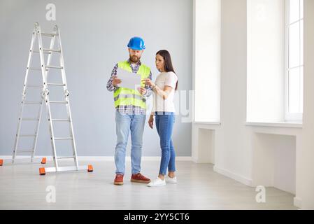 Skilled professional repairman explaining project plan, architect construction worker talking  Stock Photo