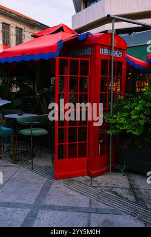 Traditional now extinct old red telephone box from England in Cypriote cafe Stock Photo