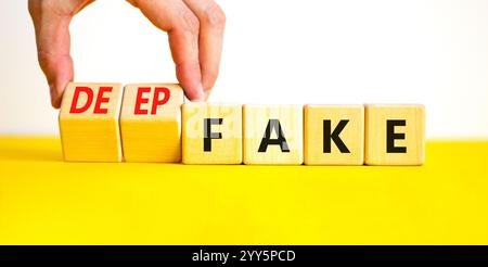 Deepfake or fake symbol. Concept words Fake Deepfake on wooden cubes. Beautiful yellow table white background. Businessman hand. Business and deepfake Stock Photo