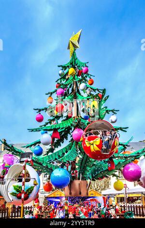 Large Christmas tree fairground roundabout with children in gondolas in city square Stock Photo