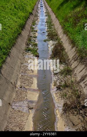 Drained Irrigation canal or irrigation channel in concrete wall sending water from the reservoir to the agricultural area of the farmer. Drained riv Stock Photo