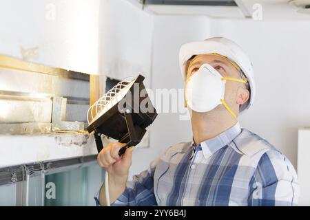 man checking the state of the ceiling Stock Photo