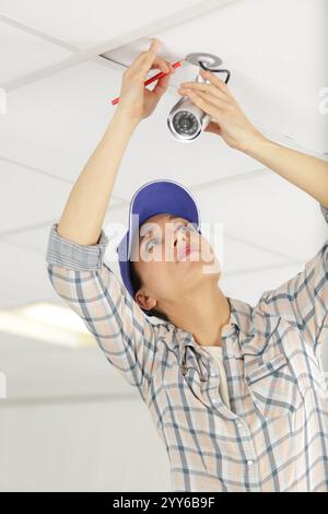 pretty female installing cctv camera Stock Photo