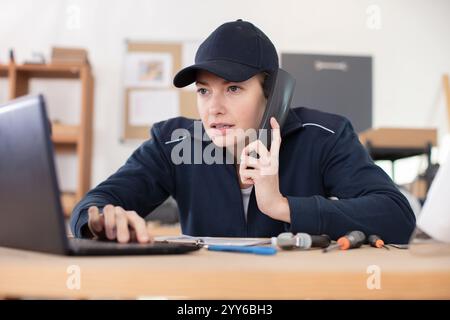 female on the phone fixing a computer Stock Photo