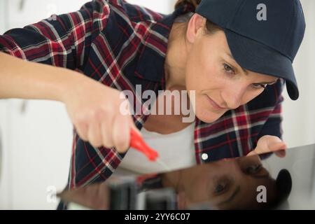 woman installing induction hobs in a kitchen Stock Photo