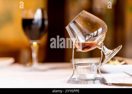 A Brandy being warmed up in a glass goblet beautifully displayed over a tea candle. Stock Photo