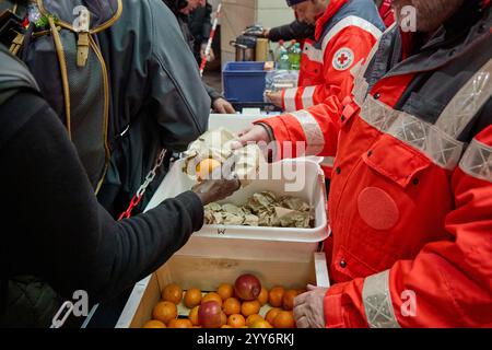 Hamburg, Germany. 19th Dec, 2024. Volunteer members of the German Red Cross (DRK) distribute food to homeless people at Gerhart-Hauptmann-Platz. Credit: Georg Wendt/dpa/Alamy Live News Stock Photo