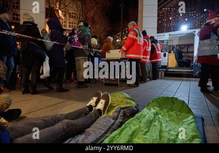 Hamburg, Germany. 19th Dec, 2024. Volunteer members of the German Red Cross (DRK) distribute food to homeless people at Gerhart-Hauptmann-Platz. Credit: Georg Wendt/dpa/Alamy Live News Stock Photo