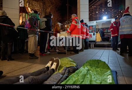 Hamburg, Germany. 19th Dec, 2024. Volunteer members of the German Red Cross (DRK) distribute food to homeless people at Gerhart-Hauptmann-Platz. Credit: Georg Wendt/dpa/Alamy Live News Stock Photo