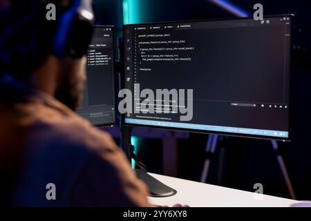Programmer writing code on computer to futureproof company network from downtimes and unexpected system failures. Man deploying programming script increasing data security Stock Photo