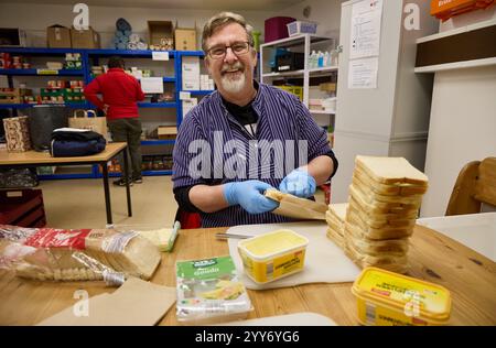 Hamburg, Germany. 19th Dec, 2024. Oliver Tomsky, a volunteer member of the German Red Cross (DRK), packs loaves of bread that will later be distributed to people in need in the city center. Credit: Georg Wendt/dpa/Alamy Live News Stock Photo