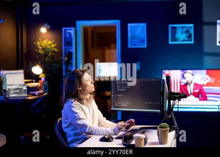 Developer in neon lit apartment implement security measures using augmented reality tech, protecting data. System administrator working from home, debugging code, looking at AR visualization Stock Photo