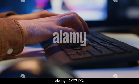 Focus on computer peripheral used by IT admin to type lines of code on desktop PC in apartment. Close up shot of keyboard used by software engineer programming at home, camera A Stock Photo