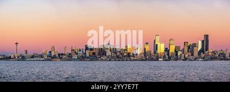 Panoramic view of the Seattle skyline at sunset, featuring the iconic Space Needle, modern skyscrapers, and the vibrant colors of dusk. Stock Photo