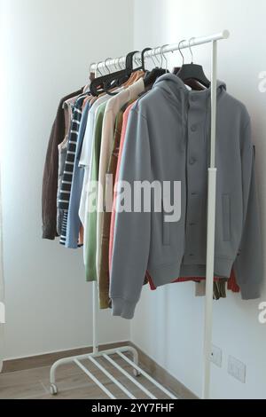 Modern clothes in room on white rack. Storage and cleanliness.  Stock Photo