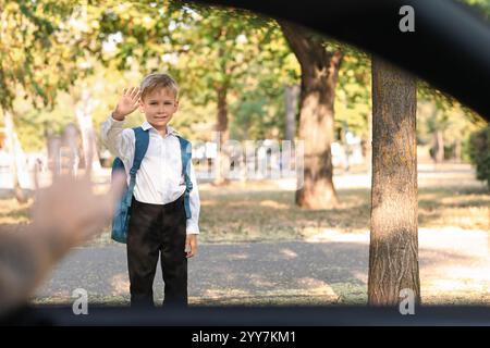 Father waving hand to his son near school, view from inside the car Stock Photo