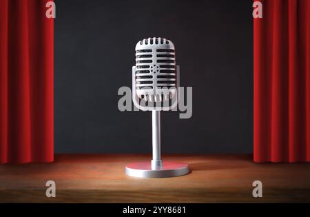 Vintage metal microphone with stand on a stage with wooden platform and red open curtains illuminated with a spotlight and black background. Stock Photo
