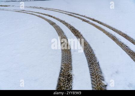 Tyre tracks made with aggressive tyre tread pattern on freshly fallen snow. Stock Photo