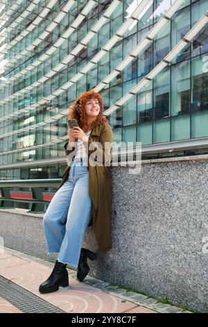 Woman listening to music with headphones and using phone in the city Stock Photo