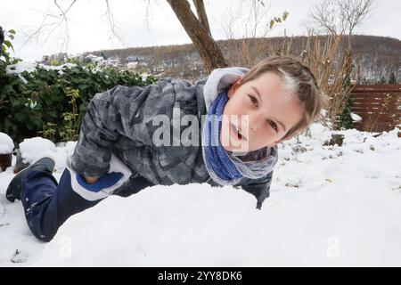 Boy playing on snow and enjoying winter outdoors Stock Photo